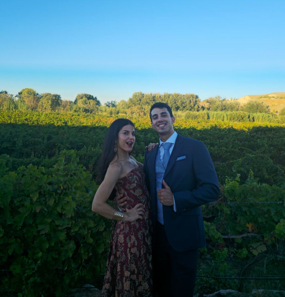 David y Lucía juntos al aire libre, vestidos de celebración